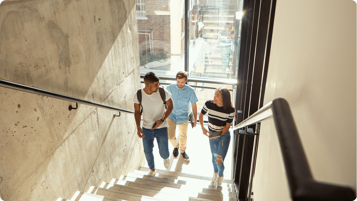 Three tertiary student walking up a flight of stairs