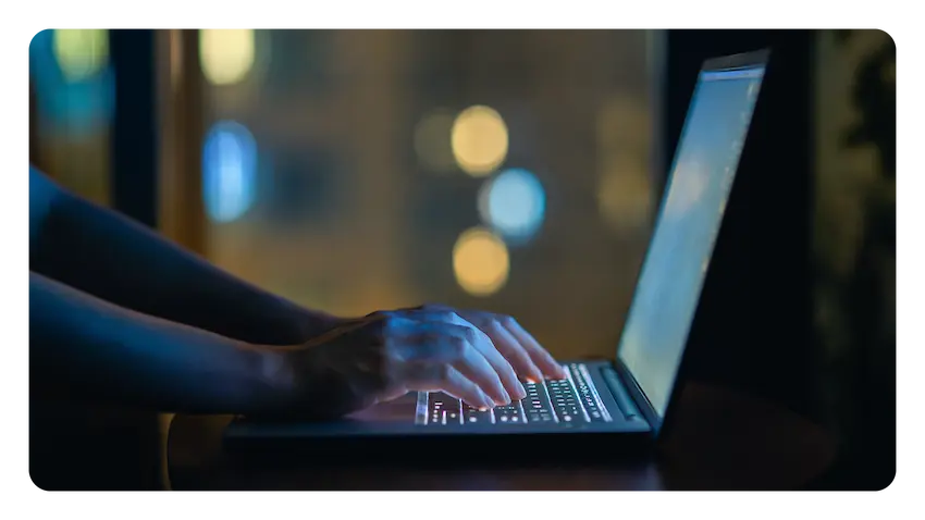 Les mains d'une personne tapant sur le clavier de son ordinateur portable